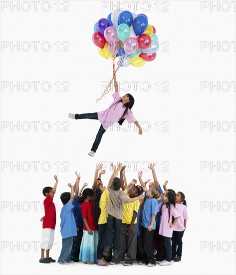 Girl floating away with balloons. Photographer: momentimages