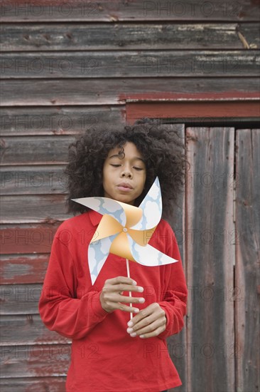 Girl blowing toy windmill. Photographer: Pauline St.Denis