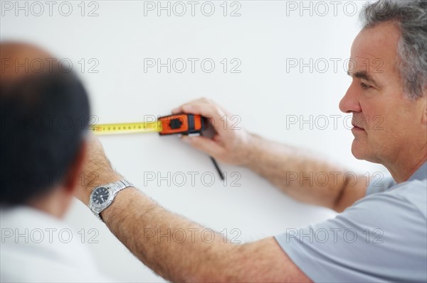 Man measuring wall. Photographer: momentimages