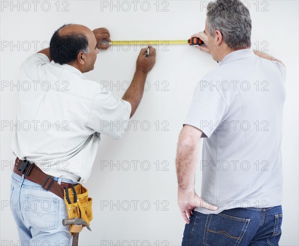 Men measuring wall. Photographer: momentimages