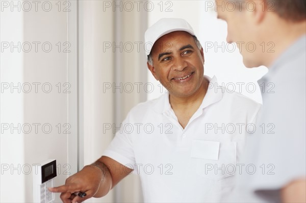 Man demonstrating how alarm system works. Photographer: momentimages