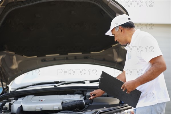 Checking car engine. Photographer: momentimages