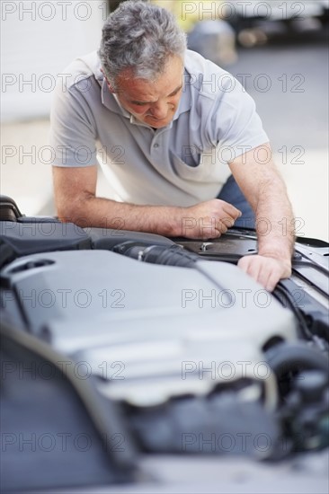 Man looking at car's engine. Photographer: momentimages