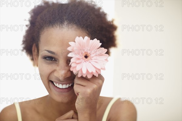 Woman holding flower. Photographer: momentimages