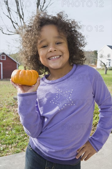 Young girl holding pumpkin. Photographer: Pauline St.Denis
