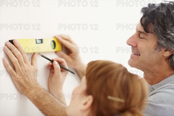 Couple using a level. Photographer: momentimages