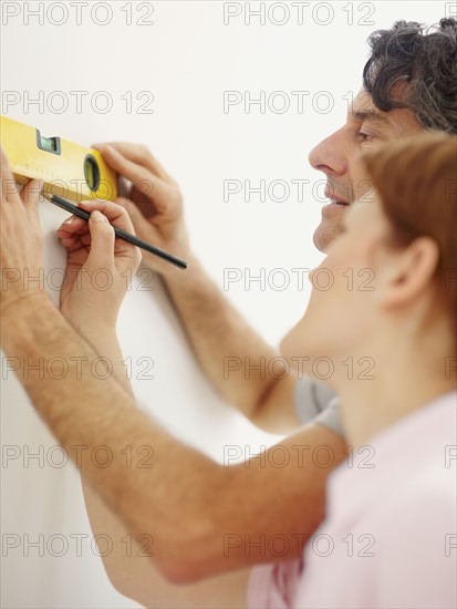 Couple using a level. Photographer: momentimages