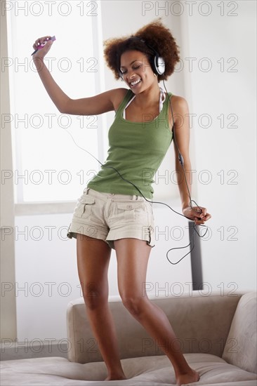 Woman dancing on couch. Photographer: momentimages