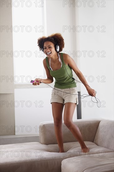 Woman dancing on couch. Photographer: momentimages