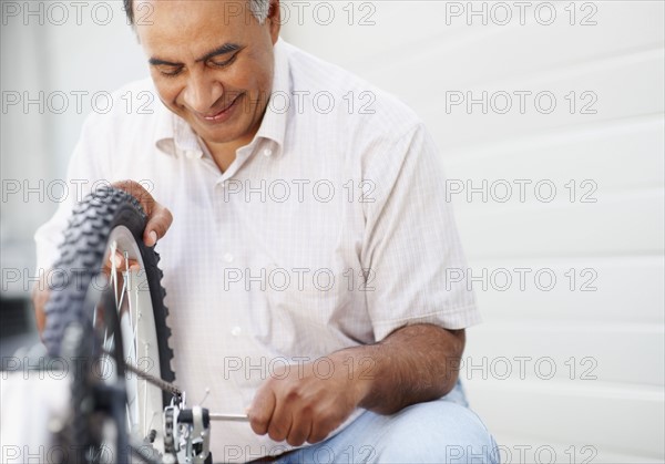 Man repairing bicycle. Photographer: momentimages