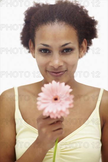 Woman holding flower. Photographer: momentimages