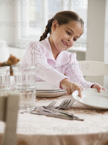 Young girl setting table. Photographer: Jamie Grill