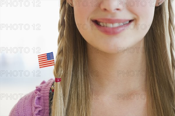 Young girl with American flag in hair.