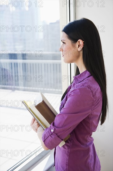 Woman looking out window. Photographer: Daniel Grill