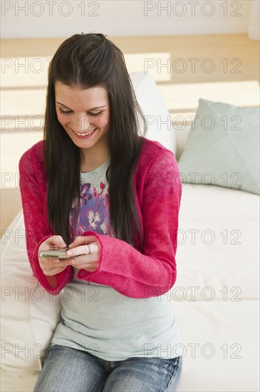 Young woman texting. Photographer: Daniel Grill