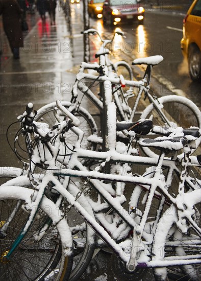 Bicycles covered in snow.