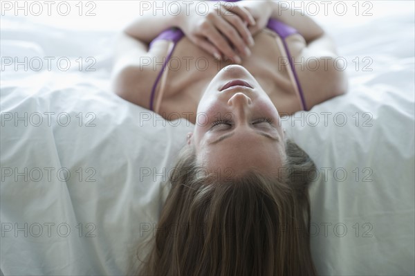 Woman lying on bed.