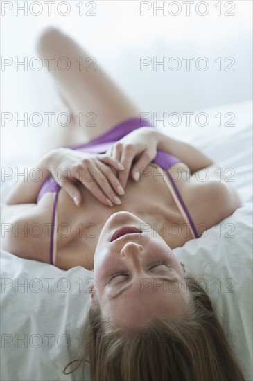 Woman lying on bed.