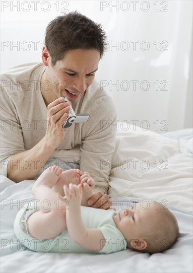 Father videotaping baby.