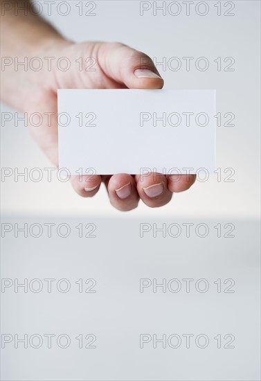 Hand holding white card.