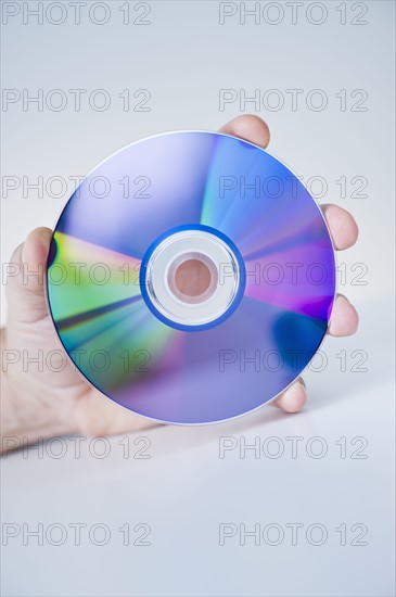 Hand holding compact disc.