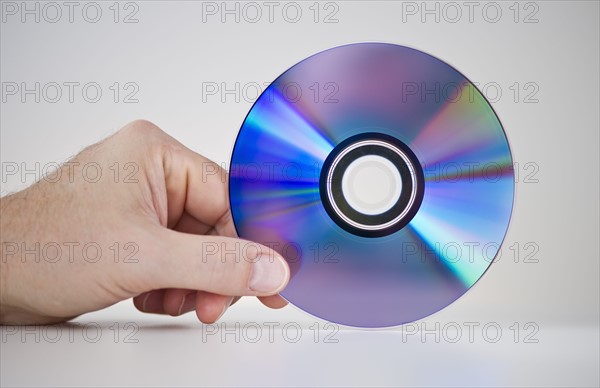 Hand holding compact disc.