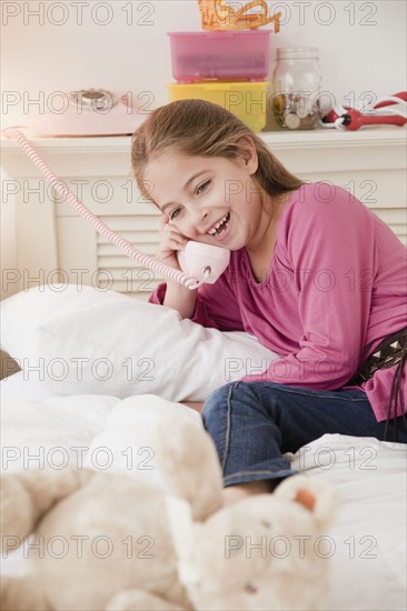 Young girl talking on telephone. Photographer: Jamie Grill