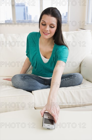 Woman reaching for handheld phone. Photographer: Daniel Grill