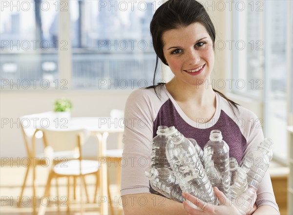 Woman holding plastic water bottles. Photographer: Daniel Grill