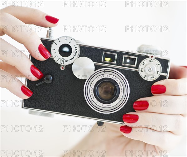 Woman holding antique camera.