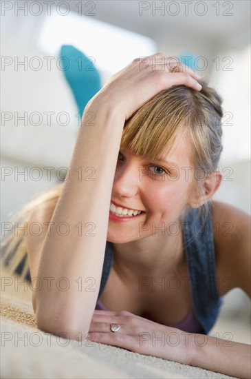 Portrait of a young woman lying on floor.