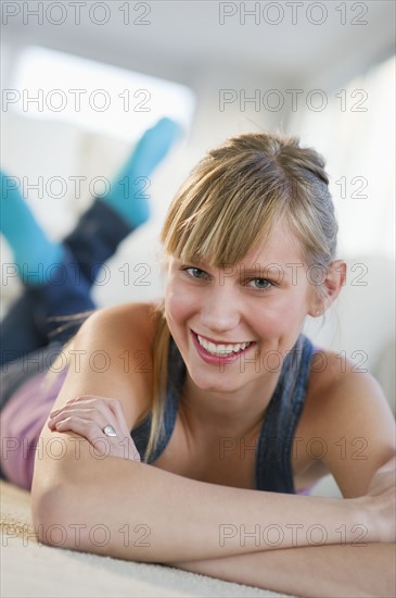 Portrait of a young woman lying on floor.