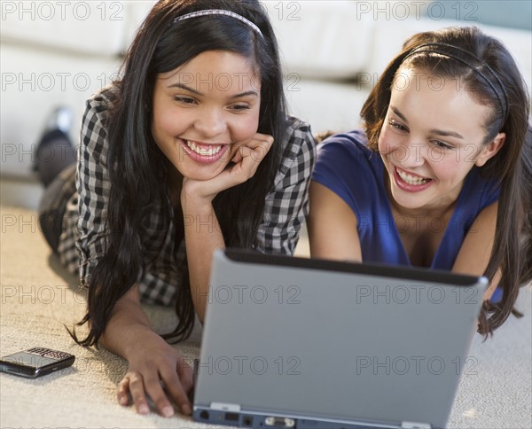 Teenage girls looking at laptop.