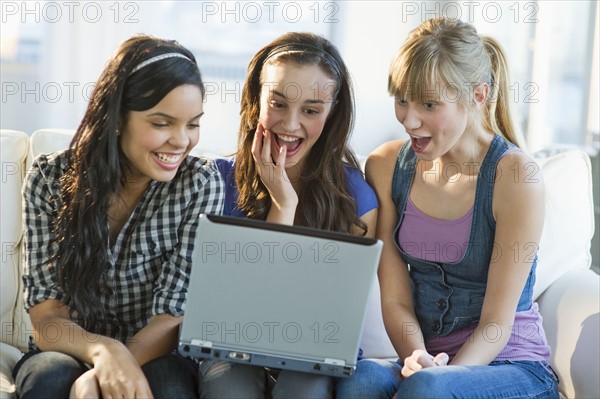 Friends looking at laptop.