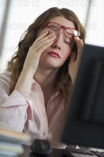 Tired woman working at computer.