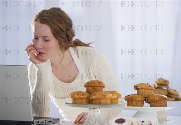 Woman baking and reading recipe.