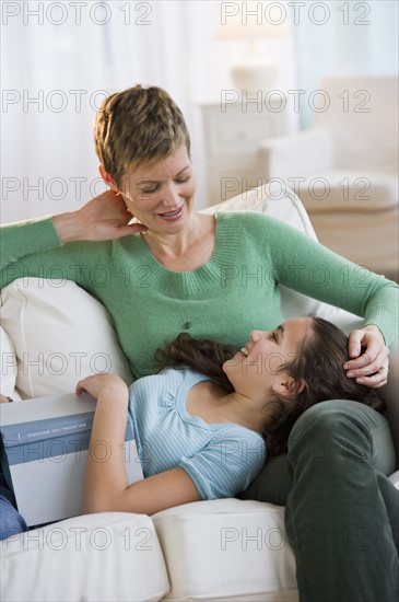 Mother and daughter relaxing on couch.