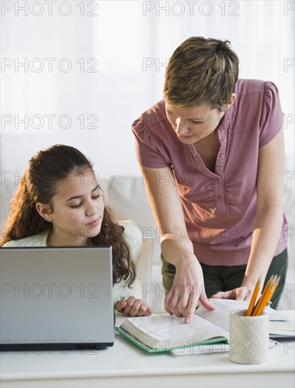 Mother helping daughter with her homework.