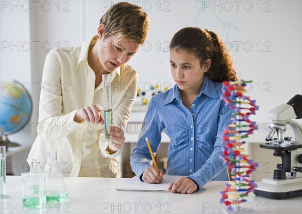 Teacher helping student in science lab.