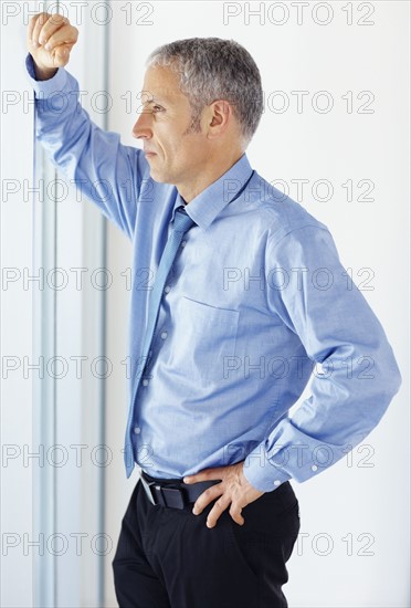 Businessman looking out window. Photographe : momentimages