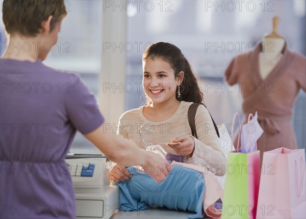 Young girl paying for clothing.