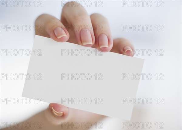 Hand holding a blank business card.