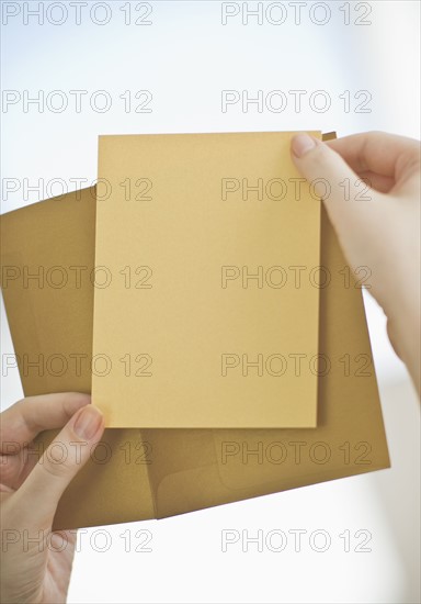 Hands holding a blank card.