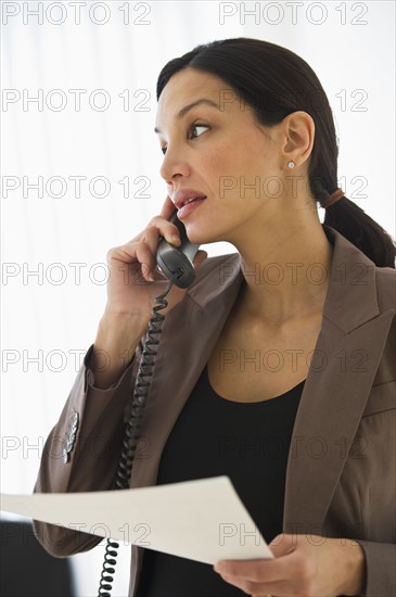 Businesswoman talking on phone in office.