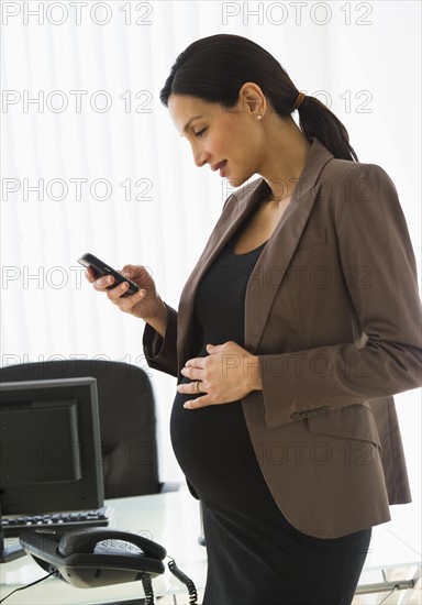 Businesswoman texting on wireless phone.