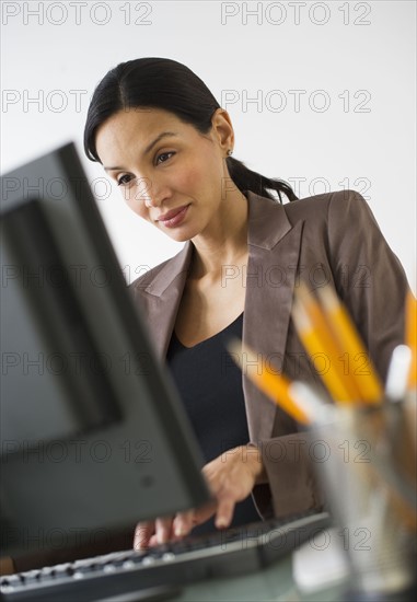 Pregnant businesswoman working on computer.