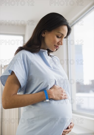 Pregnant woman wearing hospital gown.