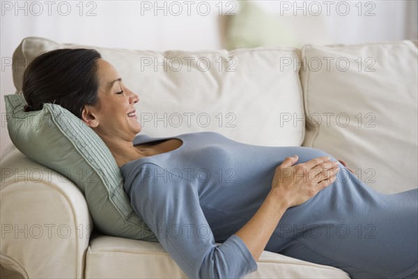 Pregnant woman resting on couch.