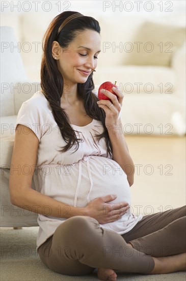 Pregnant woman eating an apple.