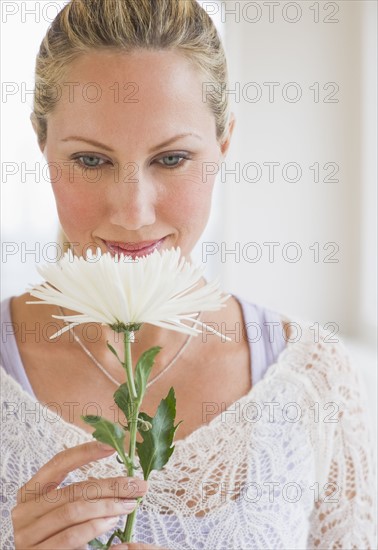Woman smelling a white flower.